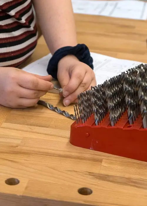 Chancengleichheit in der Berufsorientierung – Das Bild zeigt einen Schüler in der Metallwerkstatt der Gesamtschule Nord in Essen bei der Auswahl von Bohraufsätzen. 