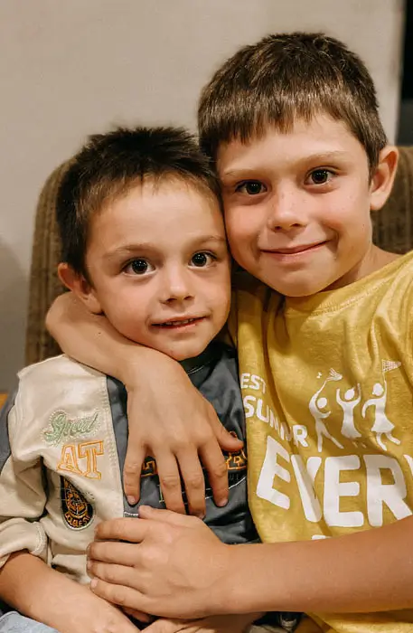 Einsatz gegen Kinderarmut – zwei Freunde Arm in Arm im Familienzentrum Stern im Norden