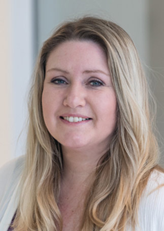 Porträtfoto einer lächelnden Frau mit langen blonden Haaren