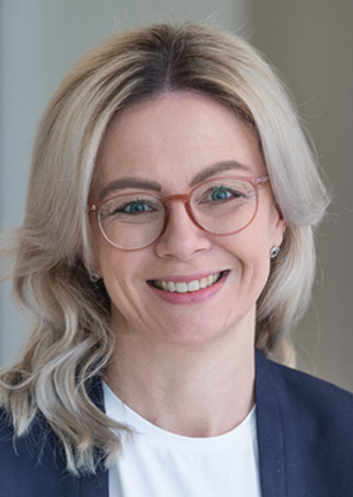 Porträtfoto einer lächelnden Frau mit mittellangen blonden Haaren