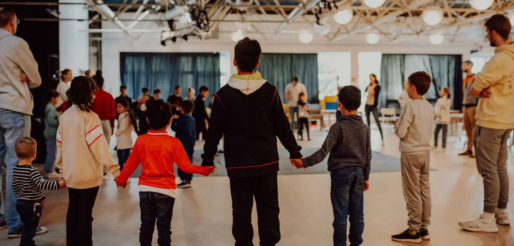 Einsatz gegen Kinderarmut – Kinder spielen und halten sich an den Händen im Familienzentrum Stern im Norden.