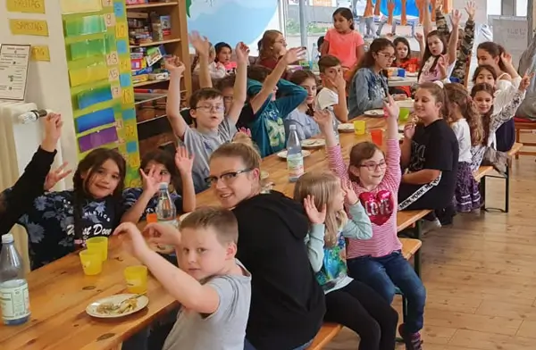 Soziale Integration – Auf dem Bild sind fröhliche Kinder beim gemeinsamen Essen bei WiLLmA zu sehen.